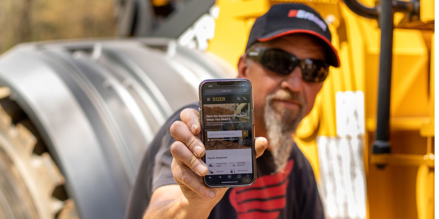 Contractor holding a phone with the DOZR website